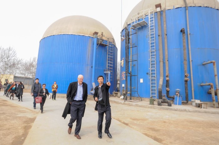 Paulson Institute Chairman Hank Paulson hears from Zhou Hanhua, owner of a pig farm, about the farm’s waste-to-energy system and how it contributes to mitigating air pollution from ammonia