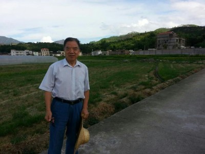Liu Denggo stands in front of soy bean crops in Dapu county, Guangdong province