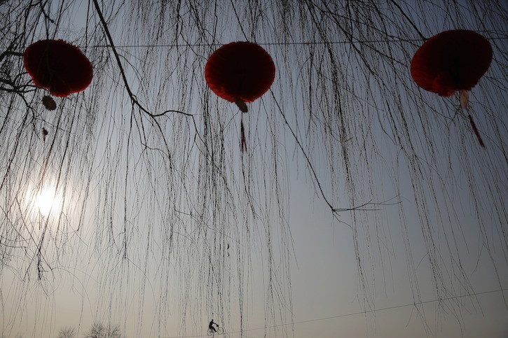 An acrobat performs on a tightrope as the Chinese Lunar New Year which welcomes the Year of the Monkey is celebrated at Daguanyuan park in Beijing