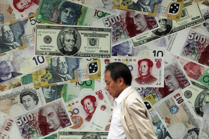 A man walks past an advertisement promoting China's renminbi (RMB) or yuan ,US dollar and Euro exchange services at money exchange in Hong Kong